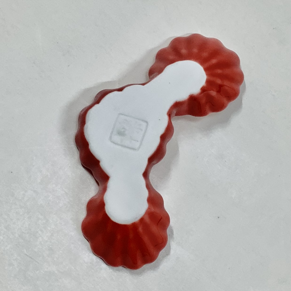 赤釉菊形箸置の画像