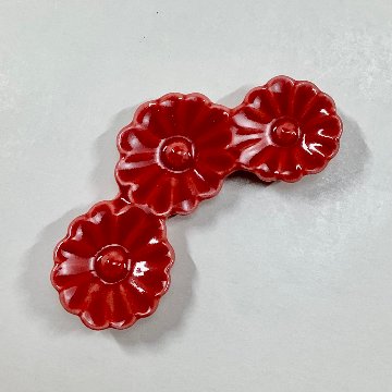 赤釉菊形箸置の画像