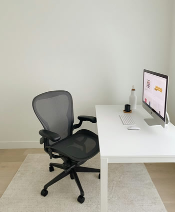 ノートパソコンの前で頭を抱えて悩むオフィスワーカー