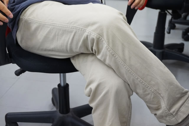 オフィスチェアに座り脚を組んだ姿勢による太もも圧迫のイメージ